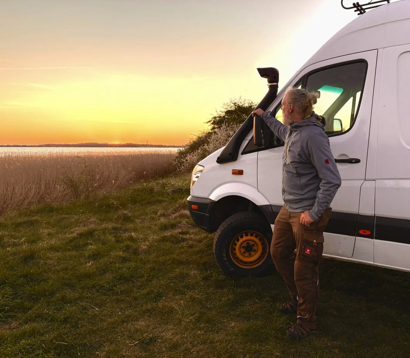 Steffen Plust auf Reisen mit seinem Wohnmobil bei Sonnenuntergang